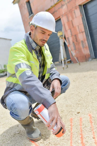 Unga lantmätare besprutning mark på golvet — Stockfoto