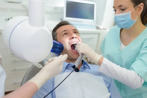 Dentista femenino y paciente masculino en clínica dental — Foto de Stock