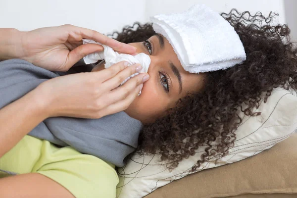 Mujer enferma acostada en la cama estornudando — Foto de Stock
