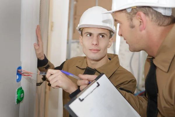 Lärling elektriker med äldre arbetstagare — Stockfoto