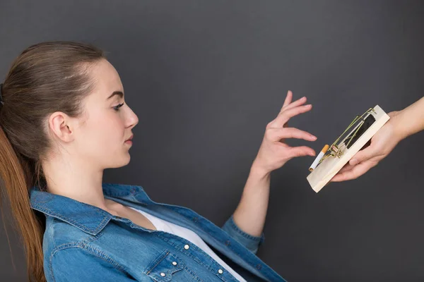 Junge Frau versucht mit Mausefalle zur Zigarette zu greifen — Stockfoto