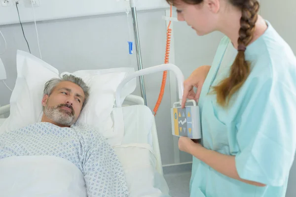 Nurse showing control to patient in ward at hospital — Stock Photo, Image