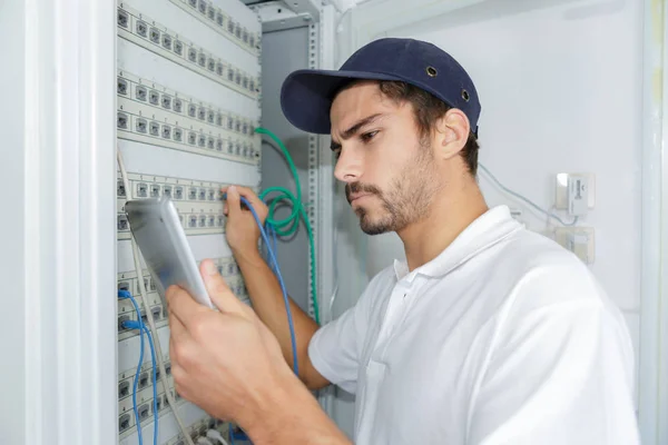 Elektryk koncentruje się stosowania procedury bezpieczeństwa podczas pracy na panelu elektrycznym — Zdjęcie stockowe