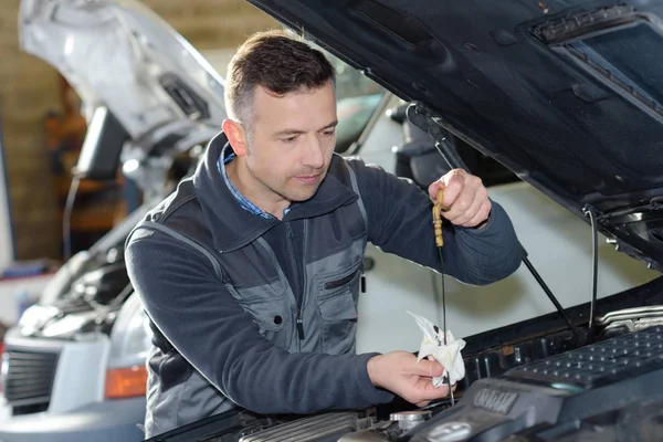 Auto monteur ter vervanging van olie op de motor in garage — Stockfoto