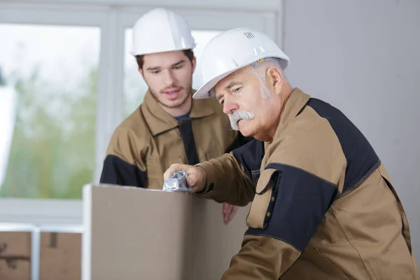 Lärare att hjälpa studerande som utbildar sig till byggare — Stockfoto