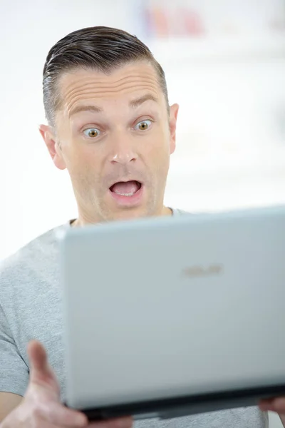 Hombre sorprendido mirando la pantalla del ordenador — Foto de Stock