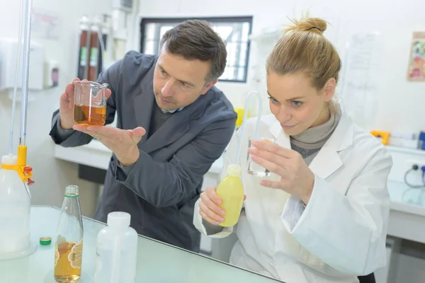 Dois cientistas que fazem experiências com líquidos diferentes — Fotografia de Stock