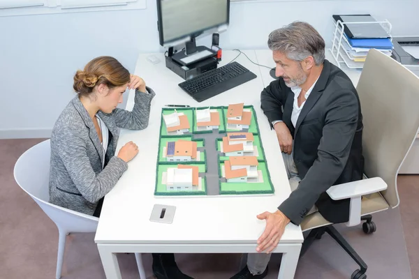 L'uomo e la donna studiano i piani per lo sviluppo edilizio — Foto Stock