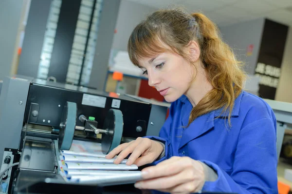 Werknemer controle drukwerk coming off van de pers — Stockfoto