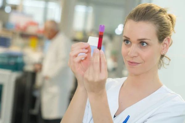 Nurse is holding a tube with blood probe — Stock Photo, Image