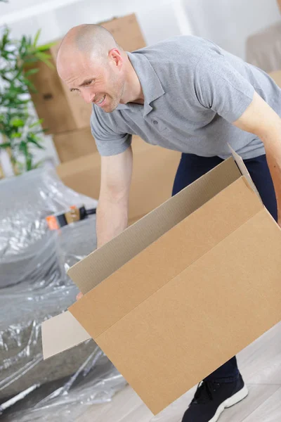 Retrato de un hombre maduro sonriente que lleva la caja — Foto de Stock