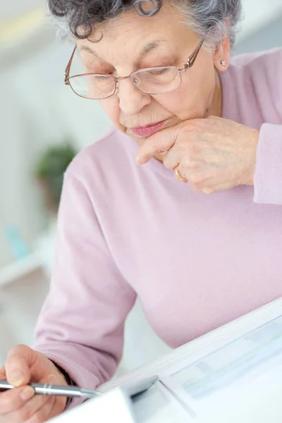 Donna anziana che calcola le tasse a casa — Foto Stock