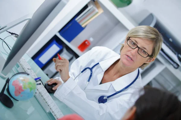 Lekarka w biały płaszcz medycznych jest doradztwo jej pacjenta — Zdjęcie stockowe