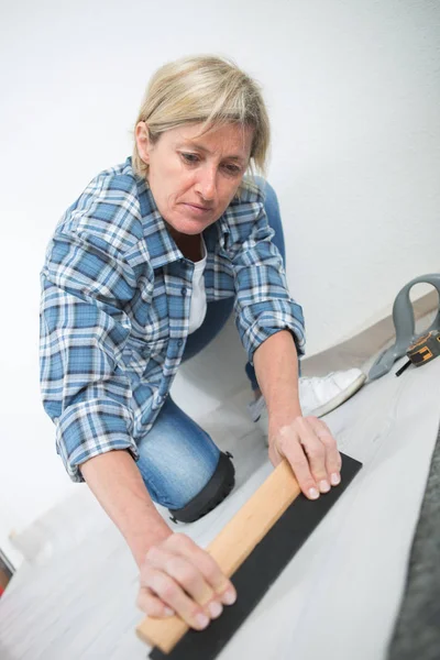 Frau beim Einbau eines Linoleumbodens — Stockfoto