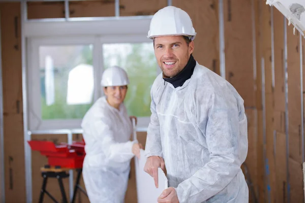 Due operai che trasportano assi in un cantiere — Foto Stock