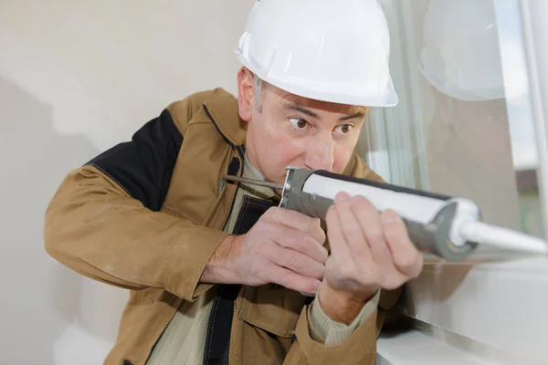 Trabajador de la construcción instalando ventana en casa — Foto de Stock