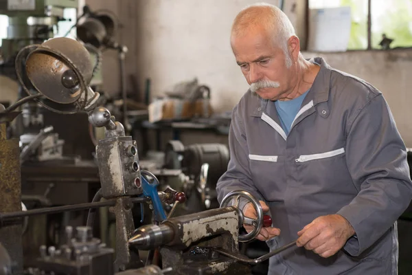 Uomo che gestisce un tornio — Foto Stock