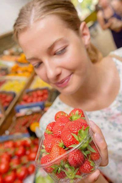 Femme regardant des fraises dans un magasin — Photo