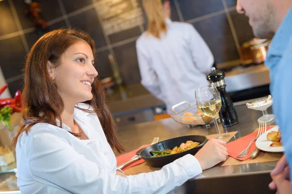 Pareja sentada en el bar comiendo comida — Foto de Stock