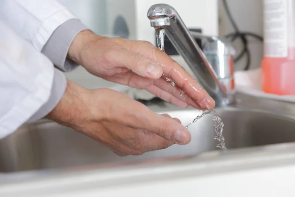 Doktor myje ruce s tekoucí vodou — Stock fotografie