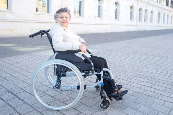 Пожилая женщина на инвалидной коляске прогуливается — стоковое фото