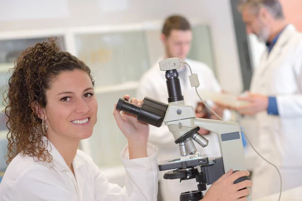 Estudiante posando sosteniendo un microscopio — Foto de Stock