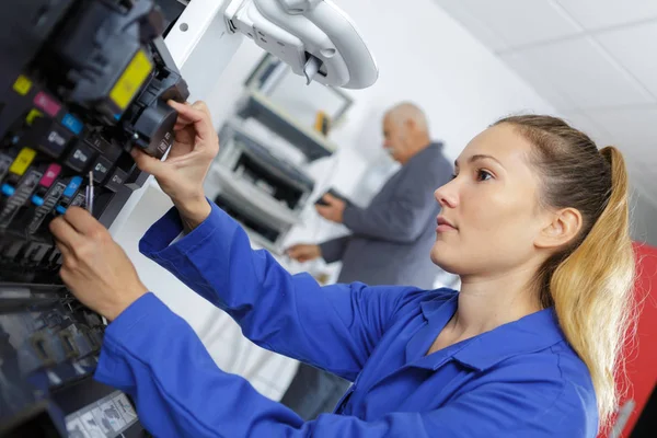 Jovem reparadora fixando cartucho na máquina de impressora no escritório — Fotografia de Stock