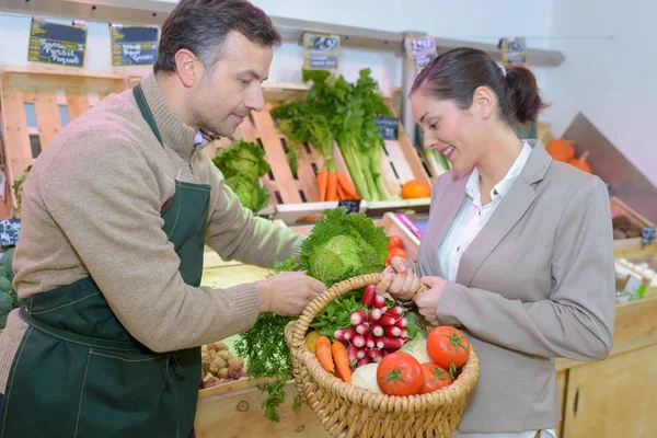 Gemüsehändlerin hilft Kundin beim Einkaufen — Stockfoto