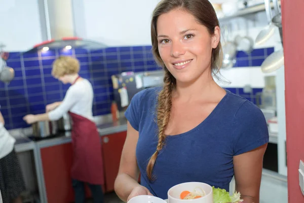 Schöne Kellnerin hält ein Gericht zum Servieren bereit — Stockfoto