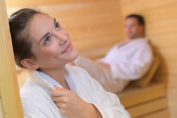 Pareja en sauna mujer con expresión lejana Imagen de archivo