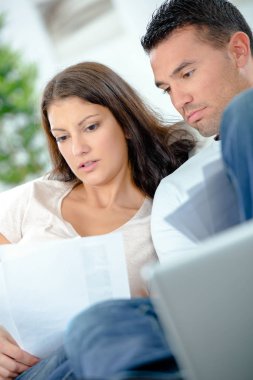 Couple looking at papers with worried expressions clipart