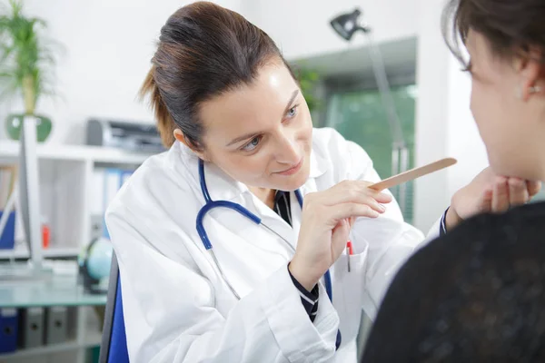 Mujer médico auscultating mujer — Foto de Stock