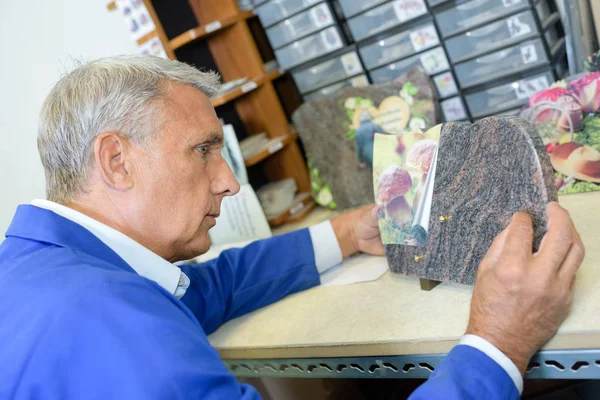 Werknemer met marmeren gedenkplaat — Stockfoto