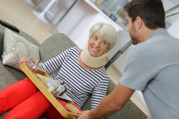 Hälso-och sjukvårdspersonal att hjälpa en äldre kvinna — Stockfoto