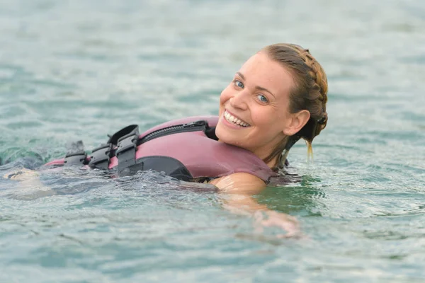 Ritratto di donna che indossa giubbotto salvagente galleggiante in acqua — Foto Stock