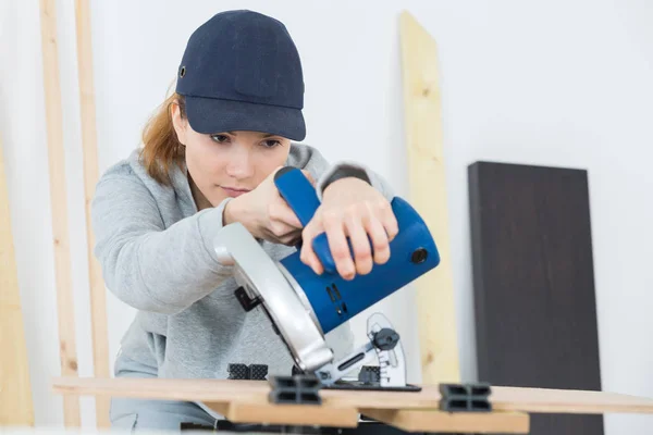 Menuisier femelle utilisant la machine sur panneau de bois — Photo