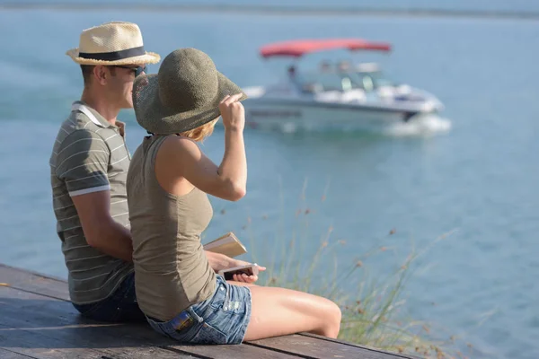 Пара на березі озера в сонячний час — стокове фото