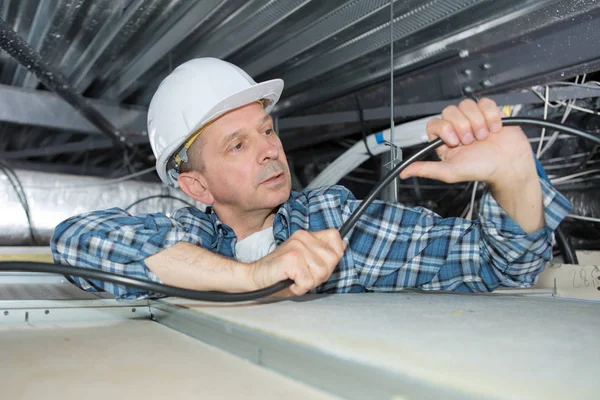 Middle-aged man worker working in ceiling — Stock Photo, Image