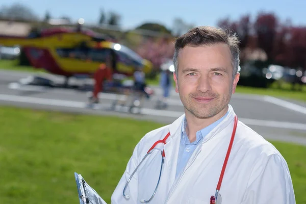 Médico em pé junto a um helicóptero — Fotografia de Stock