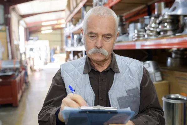 Senior stock keeper working in warehouse — Stock Photo, Image