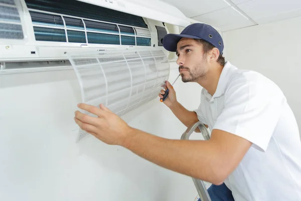 Porträtt av mitten av vuxna manliga tekniker reparera luftkonditioneringen — Stockfoto