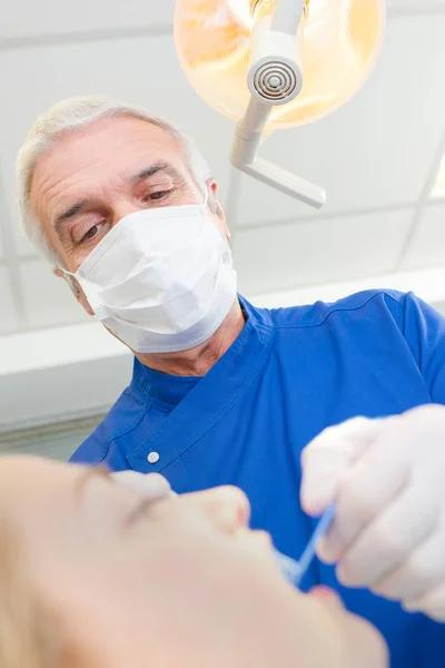 Dentista senior cuidando de las mujeres pacientes dientes —  Fotos de Stock