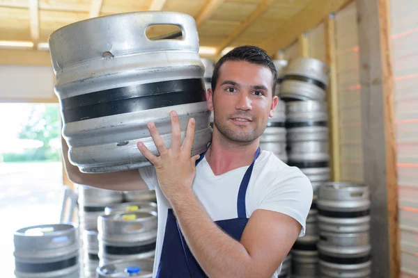 Trabalhador carregando barril com cerveja na cervejaria — Fotografia de Stock