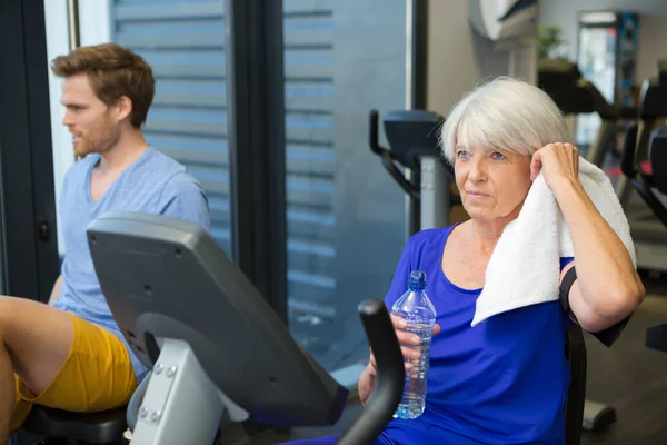 Elderly woman on the exercise machine — Stock Photo, Image