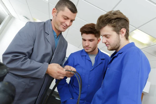 Leraar met studenten in mechanica werken — Stockfoto