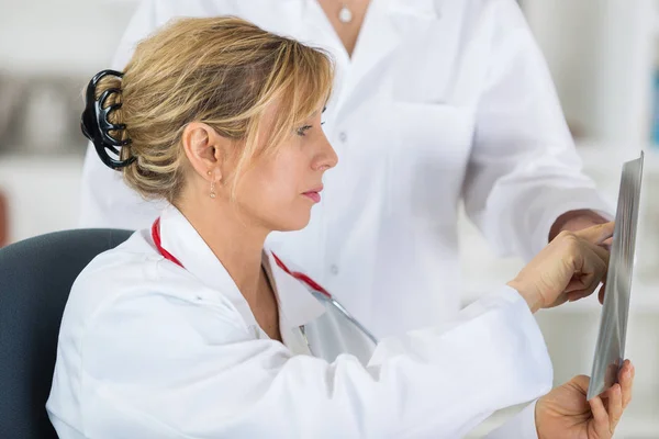 Doctores mujeres mirando y discutiendo la imagen de rayos X en el hospital —  Fotos de Stock