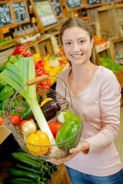 Dame hält Metallkorb mit Gemüse — Stockfoto