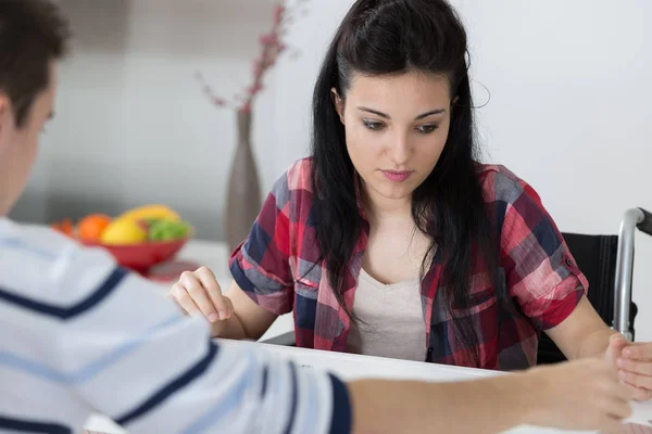 Handicapé jeune femme jouer aux échecs avec un ami à la maison — Photo