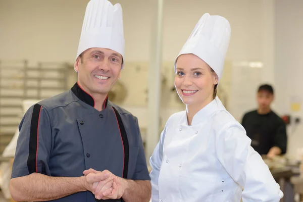 Twee positieve lachende professionele koks werken bij restaurant — Stockfoto