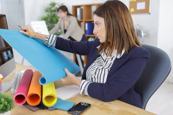 Vrouwelijke herziening van monsters in haar kantoor — Stockfoto